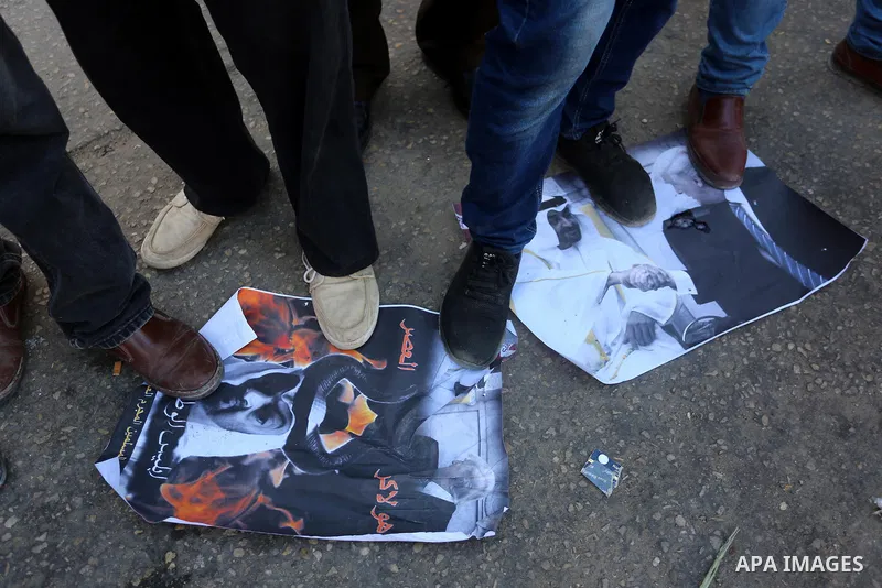 Palestinian supporters of the Popular Front for the Liberation of Palestine stomp on posters depicting the face of Abu Dhabi Crown Prince Sheikh Mohammed bin Zayed al-Nahyan, and US President Donald Trump, during a prote...