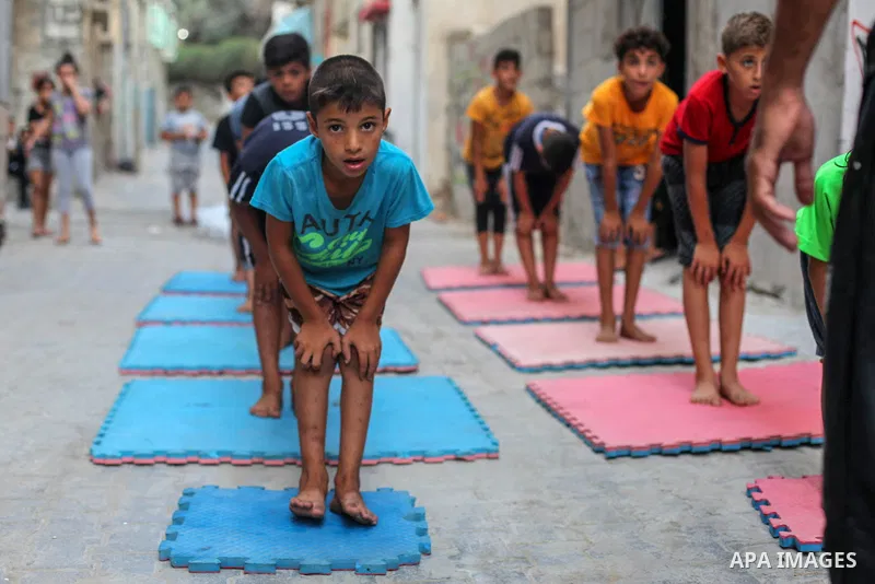 Palestinian parkour trainer Ahmed Abu Hasira "myuz",35, trains children outside his home, in Gaza City on August 18, 2020. Parkour is an activity that can be practiced alone or with others and is usually carried out in u...