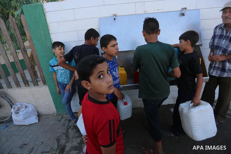 Palestinians, some of them wear masks, fill their bottles and jerry cans with drinking water from a public tap during the imposed 48-hour lockdown to mitigate virus outbreak in the Gaza Strip, in Dair Al Balah in the cen...