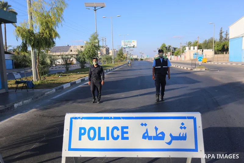 Palestinian policemen wear face masks as they guard in a street during the imposed 48-hour lockdown to mitigate virus outbreak in the Gaza Strip, in Dair Al Balah in the central of Gaza Strip on August 26, 2020. Photo by...