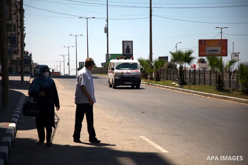 Palestinians wearing a protective masks against the spread of the coronavirus Covid-19, walk in a street during lockdown in Gaza City on August 27, 2020 amid increasing cases of infection in the Palestinian enclave. The...
