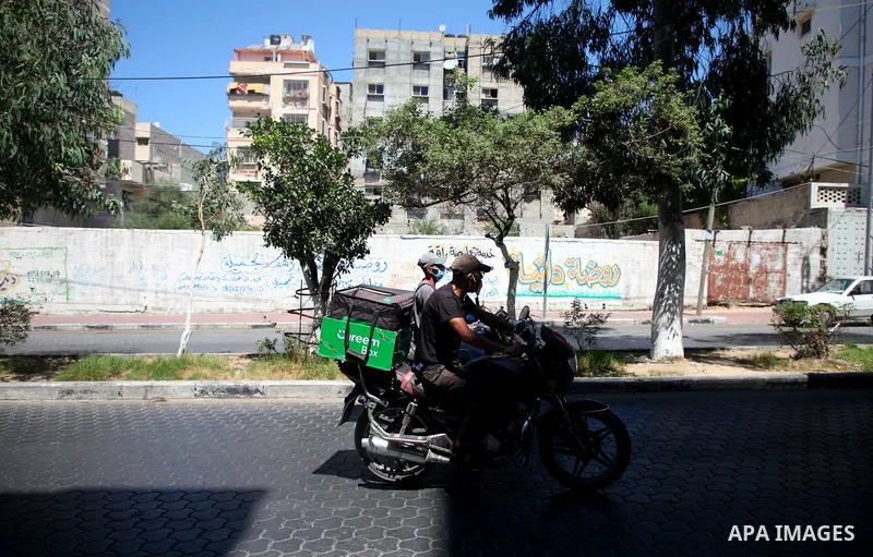 Palestinians wearing a protective masks against the spread of the coronavirus Covid-19, walk in a street during lockdown in Gaza City on August 27, 2020 amid increasing cases of infection in the Palestinian enclave. The...