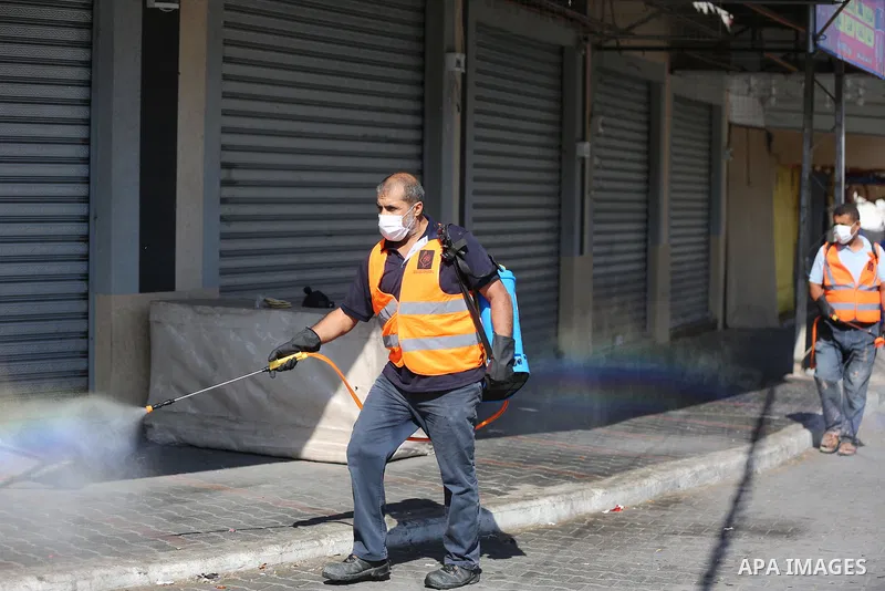 Palestinian workers wearing protective gear, disinfect a streets, during the imposed lockdown to mitigate virus outbreak in the Gaza Strip, in Dair Al Balah in the central of Gaza Strip on August 27, 2020, during a lockd...