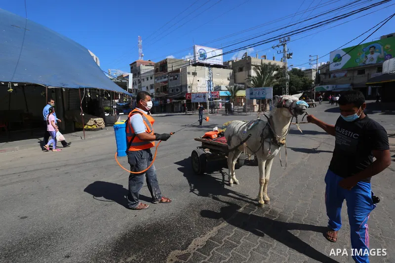 Palestinian workers wearing protective gear, disinfect a streets, during the imposed lockdown to mitigate virus outbreak in the Gaza Strip, in Dair Al Balah in the central of Gaza Strip on August 27, 2020, during a lockd...
