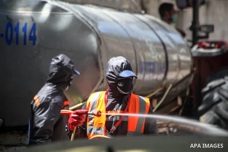 Palestinian workers wearing protective gear, disinfect a streets, during the imposed lockdown to mitigate virus outbreak in the Gaza Strip, in Beit Lahia, in the northern Gaza Strip on August 28, 2020, during a lockdown...
