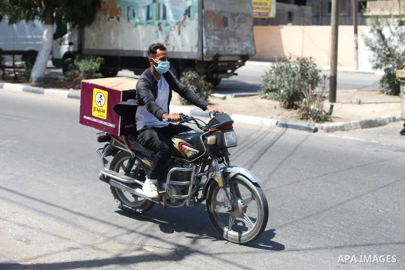 Palestinian deliverymen ride their bikes to deliver customers' orders in Gaza city on August 28, 2020, amid increasing coronavirus cases in the Palestinian enclave. Photo by Mahmoud Ajjour
