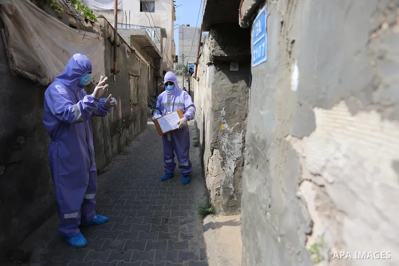 Palestinian nurses from the United Nations Relief and Works Agency for Palestinian Refugees "UNRWA" wearing protective gear, they distribute monthly treatment to chronic diseases, in Dair Al Balah in the central of Gaza...