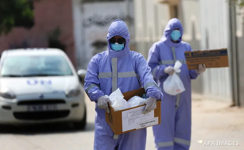Palestinian nurses from the United Nations Relief and Works Agency for Palestinian Refugees "UNRWA" wearing protective gear, they distribute monthly treatment to chronic diseases, in Dair Al Balah in the central of Gaza...