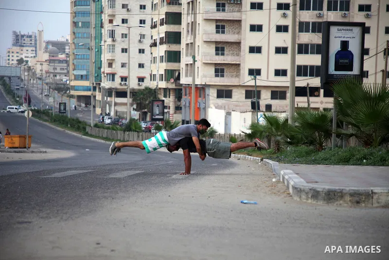 Palestinian Parkour players wear face masks show off their skills on a nearly deserted street during the imposed lockdown to mitigate virus outbreak in the Gaza Strip, in Gaza city on September 4, 2020. Photo by Mahmoud...