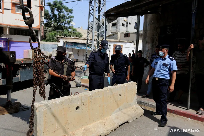 Palestinian policemen close a road with concrete barriers during a lockdown following the outbreak of the coronavirus disease (COVID-19), in Dair Al Balah in the central of Gaza Strip, on September 5, 2020. Photo by Ashr...