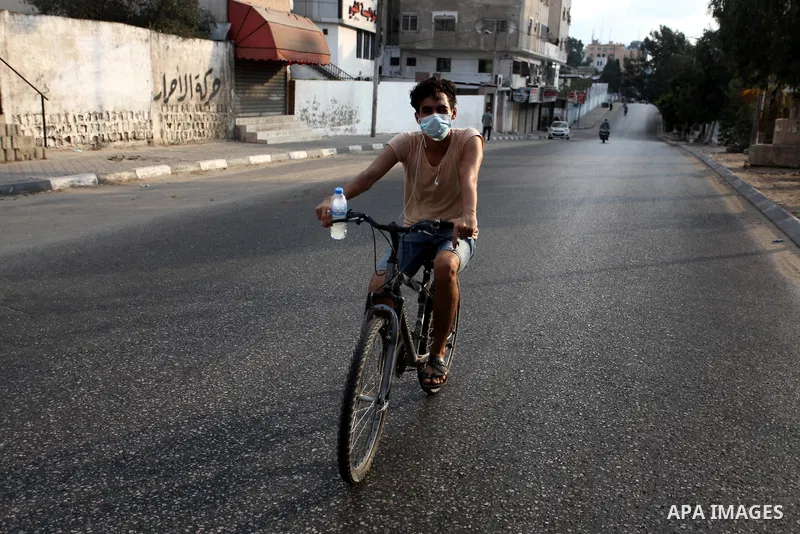 Palestinians wear face masks as they walk in a street during a lockdown following the outbreak of the coronavirus disease (COVID-19), in Gaza city on September 9, 2020. Photo by Mahmoud Ajjour