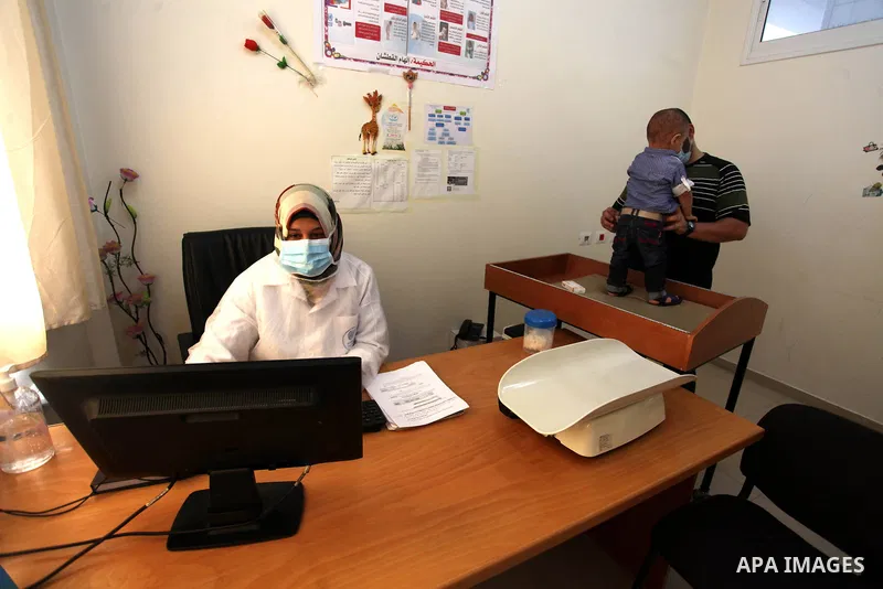 UNRWA employees wear face masks as they provide services for children in a clinic in Bureij refugee camp central of Gaza Strip on September 9, 2020. Photo by Mahmoud Ajjour