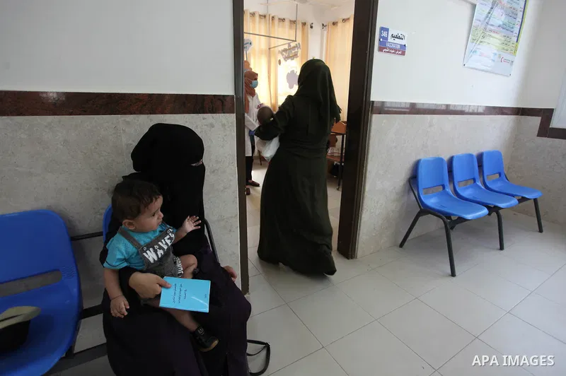 Palestinian women mask-clad due to the Covid-19 coronavirus pandemic wait with their children in a UN clinic to take Polio vaccine and Rota virus vaccines at Bureij refugee camp in the central of Gaza Strip on September...