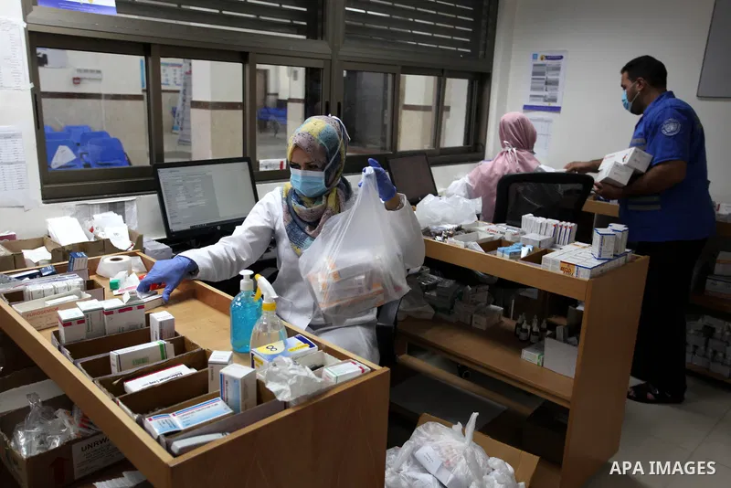 UNRWA employees wear face masks as they provide services for children in a clinic in Bureij refugee camp central of Gaza Strip on September 9, 2020. Photo by Mahmoud Ajjour