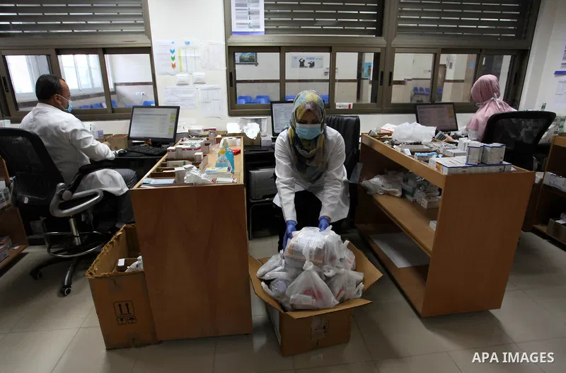 UNRWA employees wear face masks as they provide services for children in a clinic in Bureij refugee camp central of Gaza Strip on September 9, 2020. Photo by Mahmoud Ajjour