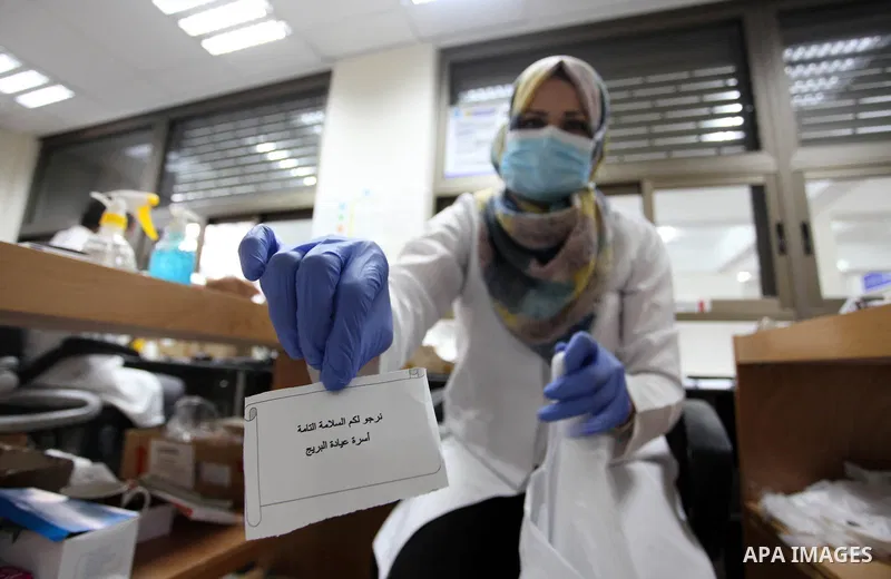 UNRWA employees wear face masks as they provide services for children in a clinic in Bureij refugee camp central of Gaza Strip on September 9, 2020. Photo by Mahmoud Ajjour