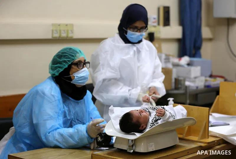 Palestinian employees wear face masks as they provide Polio vaccine and Rota virus vaccines for children at a health center in Dair Al Balah in the central of Gaza Strip, on Sept. 9, 2020. Photo by Ashraf Amra