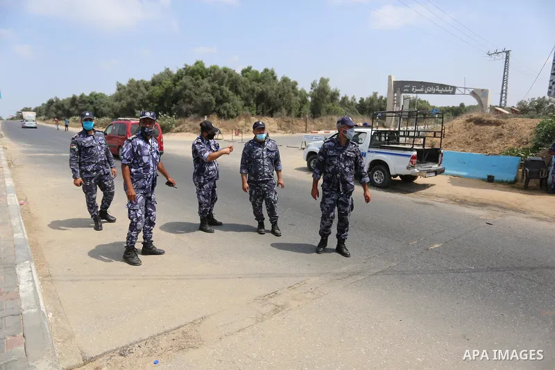 Palestinian policemen wear face masks, guard a barrier blocking a road, in Deir Al-Balah, in the center of the Gaza Strip, on Sept. 10, 2020, during a lockdown amid the COVID-19 pandemic. Photo by Ashraf Amra