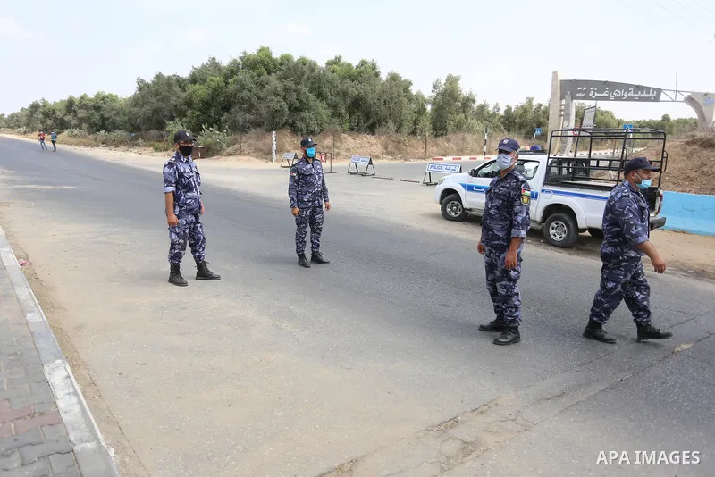 Palestinian policemen wear face masks, guard a barrier blocking a road, in Deir Al-Balah, in the center of the Gaza Strip, on Sept. 10, 2020, during a lockdown amid the COVID-19 pandemic. Photo by Ashraf Amra