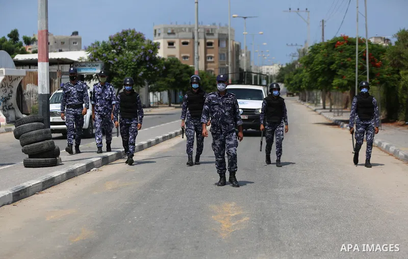 Palestinian policemen wear face masks, guard a barrier blocking a road, in Deir Al-Balah, in the center of the Gaza Strip, on Sept. 10, 2020, during a lockdown amid the COVID-19 pandemic. Photo by Ashraf Amra