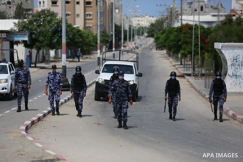 Palestinian policemen wear face masks, guard a barrier blocking a road, in Deir Al-Balah, in the center of the Gaza Strip, on Sept. 10, 2020, during a lockdown amid the COVID-19 pandemic. Photo by Ashraf Amra