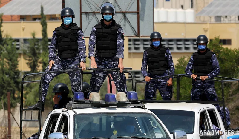 Palestinian policemen wear face masks, guard a barrier blocking a road, in Deir Al-Balah, in the center of the Gaza Strip, on Sept. 10, 2020, during a lockdown amid the COVID-19 pandemic. Photo by Ashraf Amra