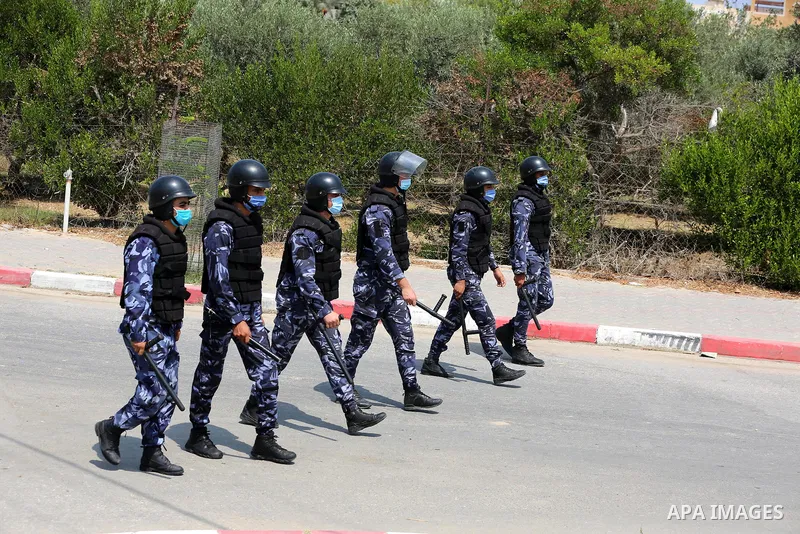 Palestinian policemen wear face masks, guard a barrier blocking a road, in Deir Al-Balah, in the center of the Gaza Strip, on Sept. 10, 2020, during a lockdown amid the COVID-19 pandemic. Photo by Ashraf Amra
