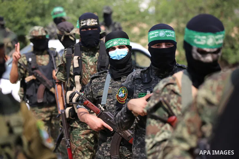 Palestinian members of al-Qassam Brigades, the armed wing of the Hamas movement, distribute protective masks to people on the street amid the Covid-19 coronavirus pandemic, in Nuseirat in the central of Gaza Strip on Sep...