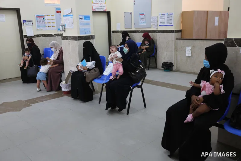 Palestinian women mask-clad due to the Covid-19 coronavirus pandemic wait with their children in a UN clinic to take Polio vaccine and Rota virus vaccines, in Deir Al-Balah, in the center of the Gaza Strip, on Sept. 12,...
