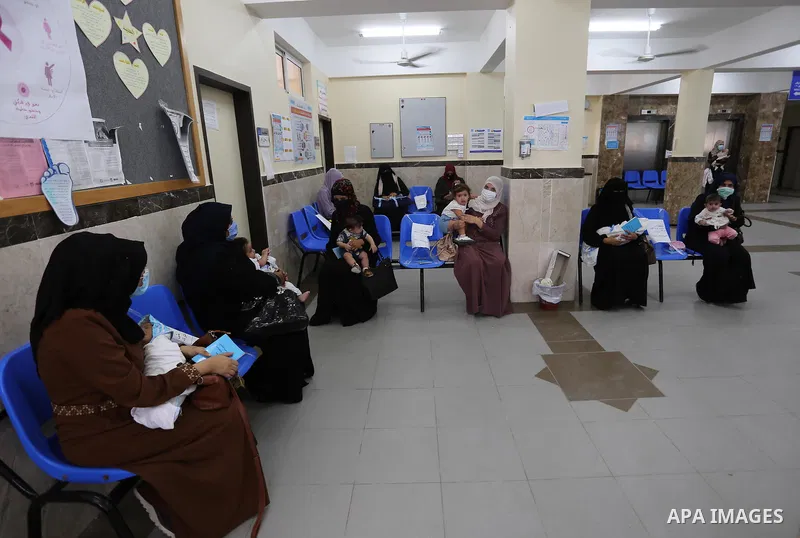 Palestinian women mask-clad due to the Covid-19 coronavirus pandemic wait with their children in a UN clinic to take Polio vaccine and Rota virus vaccines, in Deir Al-Balah, in the center of the Gaza Strip, on Sept. 12,...