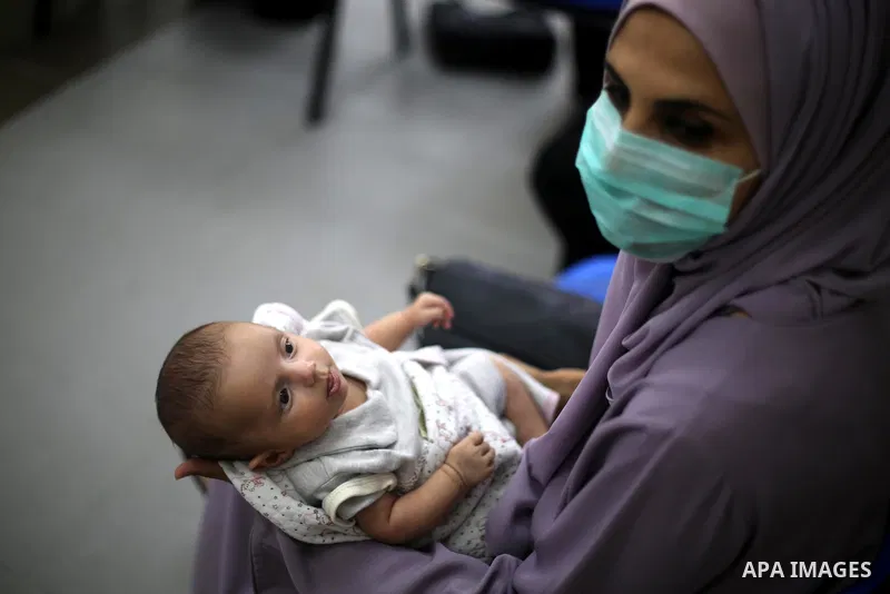 Palestinian women mask-clad due to the Covid-19 coronavirus pandemic wait with their children in a UN clinic to take Polio vaccine and Rota virus vaccines, in Deir Al-Balah, in the center of the Gaza Strip, on Sept. 12,...