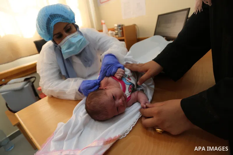 A UNRWA employee wears face mask as she provides Polio vaccine and Rota virus vaccines for children in a clinic, in Deir Al-Balah, in the center of the Gaza Strip, on Sept. 12, 2020. Photo by Ashraf Amra