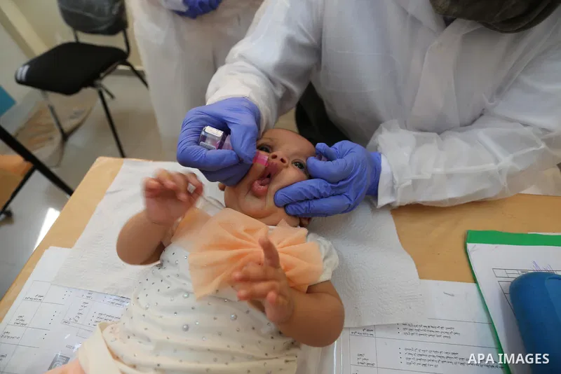 A UNRWA employee wears face mask as she provides Polio vaccine and Rota virus vaccines for children in a clinic, in Deir Al-Balah, in the center of the Gaza Strip, on Sept. 12, 2020. Photo by Ashraf Amra