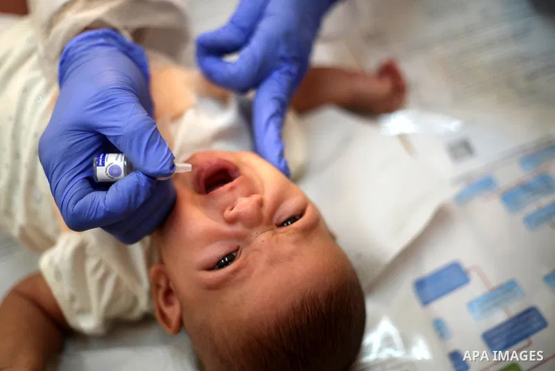 A UNRWA employee wears face mask as she provides Polio vaccine and Rota virus vaccines for children in a clinic, in Deir Al-Balah, in the center of the Gaza Strip, on Sept. 12, 2020. Photo by Ashraf Amra
