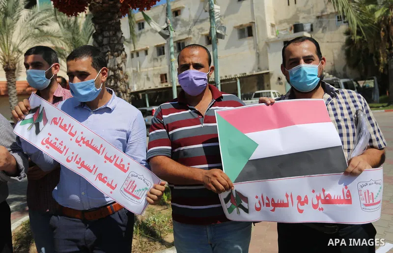 Palestinian men carry banners during a solidarity with the Sudanese people in Deir Al-Balah in central Gaza strip on Septemper 13, 2020. Photo by Ashraf Amra