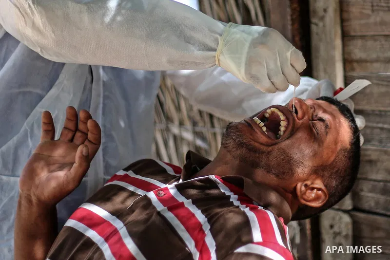 A Palestinian midical wearing protective gear, takes a swab sample from a man during a COVID-19 screening campaign in Deir Al-Balah, in the central Gaza Strip, on September 24, 2020. Photo by Ashraf Amra