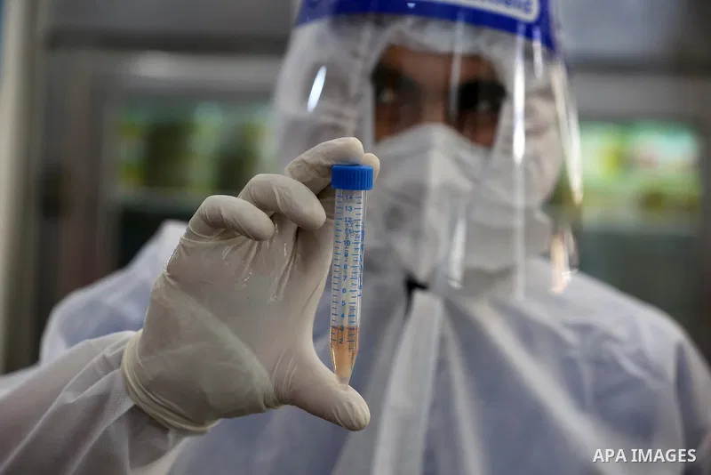 A Palestinian midical wearing protective gear, takes a swab sample from a man during a COVID-19 screening campaign in Deir Al-Balah, in the central Gaza Strip, on September 24, 2020. Photo by Ashraf Amra