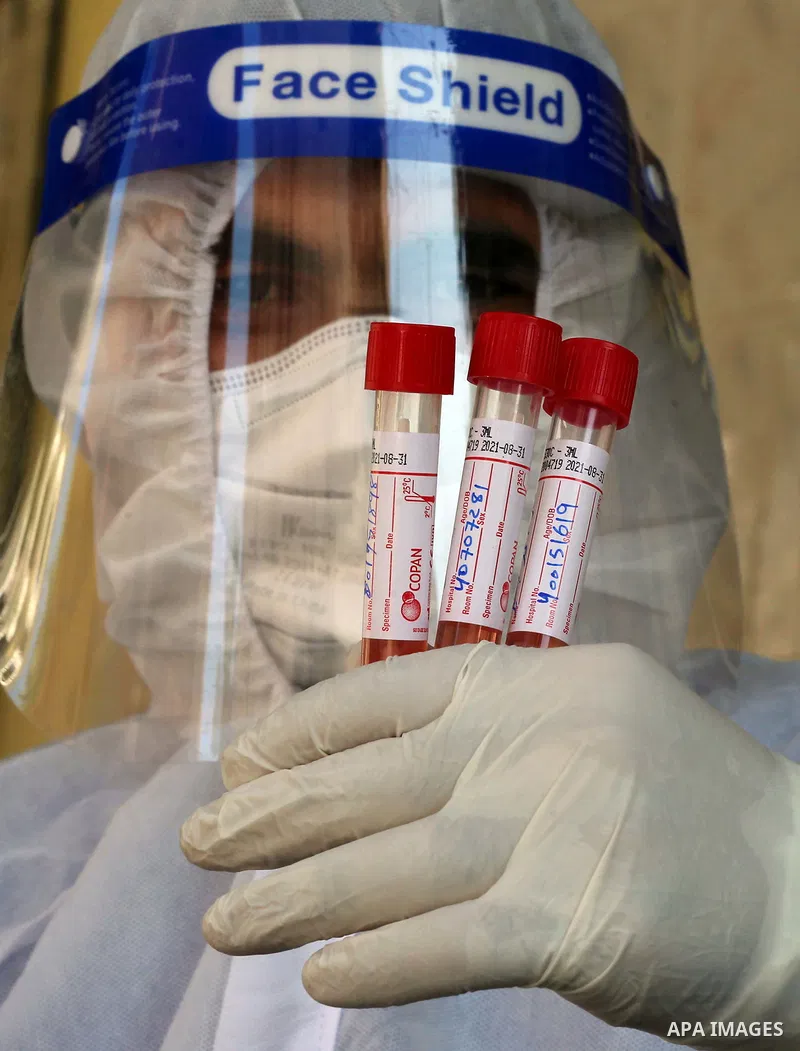 A Palestinian midical wearing protective gear, takes a swab sample from a man during a COVID-19 screening campaign in Deir Al-Balah, in the central Gaza Strip, on September 24, 2020. Photo by Ashraf Amra