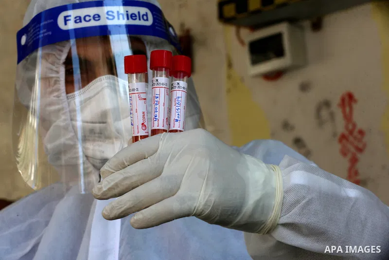 A Palestinian midical wearing protective gear, takes a swab sample from a man during a COVID-19 screening campaign in Deir Al-Balah, in the central Gaza Strip, on September 24, 2020. Photo by Ashraf Amra