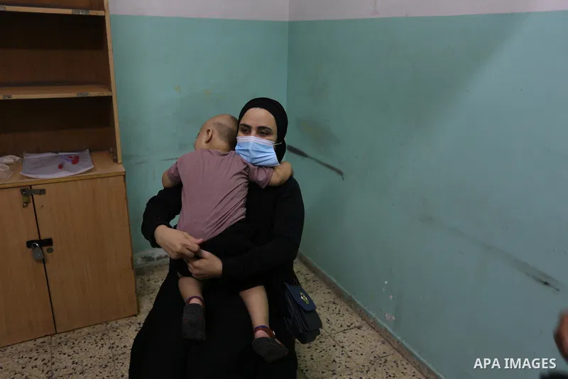 A Palestinian medical worker wearing protective gear, takes a swab sample COVID-19 screening, for travelers through the Rafah crossing after a decision to reopen it in the coming days at a health center, in Nuseirat in t...