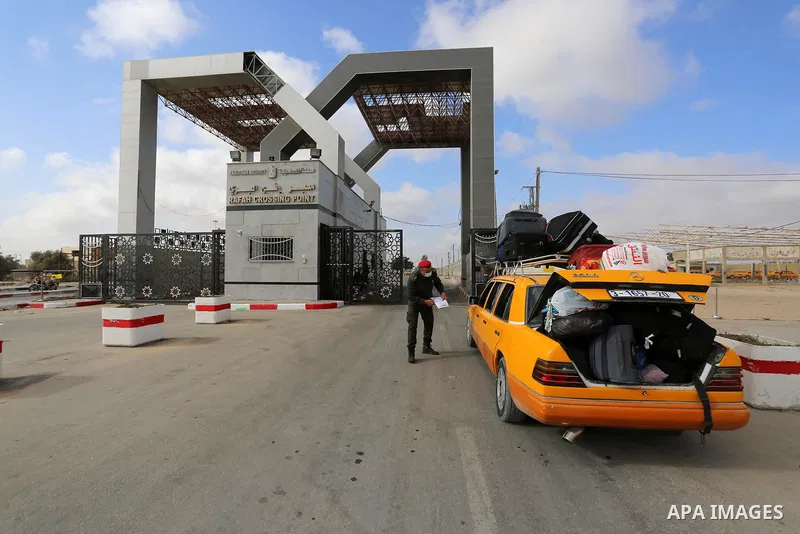 Palestinians wear face masks, as they wait for travel permits to cross into Egypt through the Rafah border crossing, which was reopened partially amid the spread of the coronavirus disease (COVID-19), in Rafah in the sou...