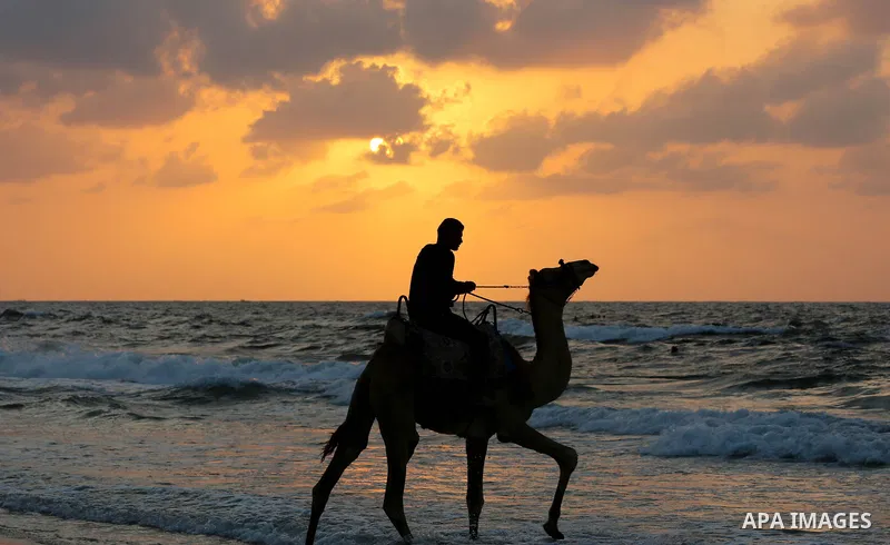 Palestinians enjoy the beach along the shore of the Mediterranean Sea during the sunset in Deir al-Balah in the central Gaza Strip on October 20, 2020. Photo by Ashraf Amra