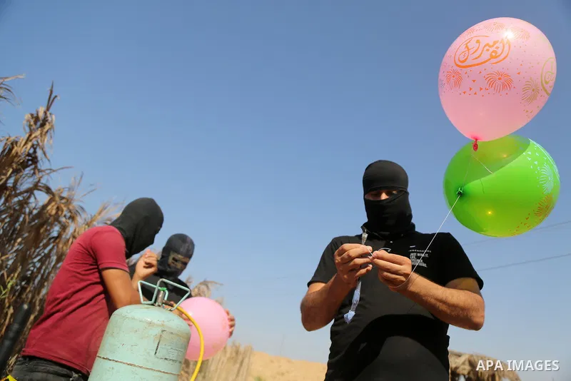 Palestinians prepare balloons attached with flammable materials to solidarity with prisoner Maher Al-Akhras on hunger strike helds in Israeli jails, at the Israel-Gaza border, in Gaza city on October 26, 2020. Photo by D...