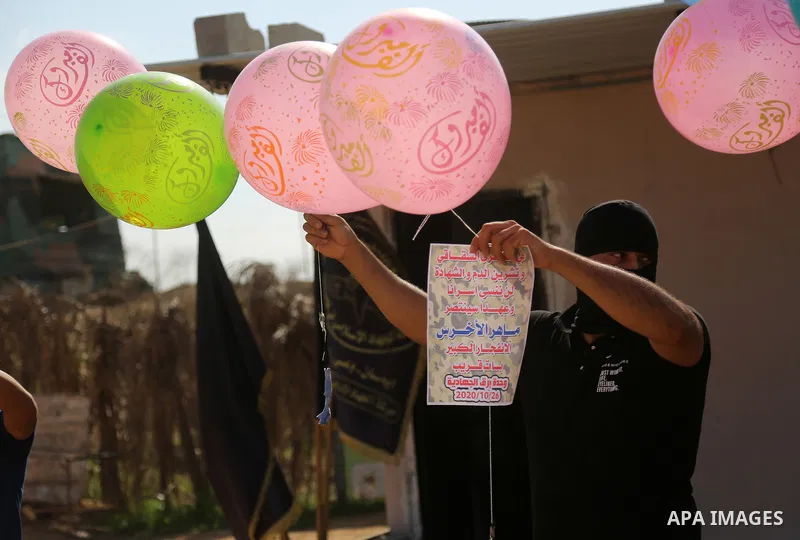 Palestinians prepare balloons attached with flammable materials to solidarity with prisoner Maher Al-Akhras on hunger strike helds in Israeli jails, at the Israel-Gaza border, in Gaza city on October 26, 2020. Photo by D...
