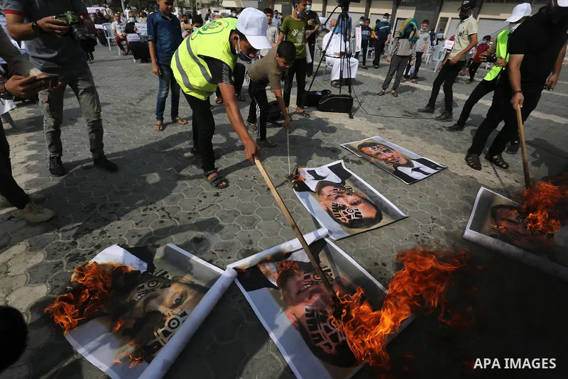 Palestinian Hamas supporters burn pictures depicting French President Emmanuel Macron during a protest against the publications of a cartoon of Prophet Mohammad in France and Macron's comments, in Khan Younis in the sout...