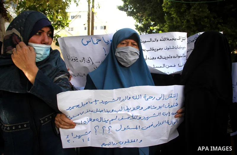 Palestinian families of martyrs and woundeds wearing protective face masks, as they take part in a protest to demand their rights and salaries, in Gaza city, on November 10, 2020. Photo by mohammed salem