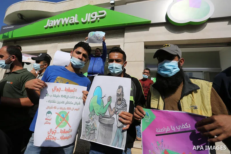 Palestinian protesters take part in a rally in front of the mobile company (jawwal), against the high prices and the bad services of the company in Deir Al-Balah, in the central Gaza Strip, on November 10, 2020. Photo by...
