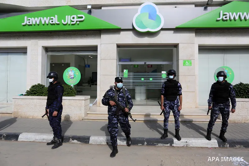 Palestinian police stand in front of the mobile company (jawwal), during a rally against the high prices and the bad services of the company in Deir Al-Balah, in the central Gaza Strip, on November 10, 2020. Photo by Ash...