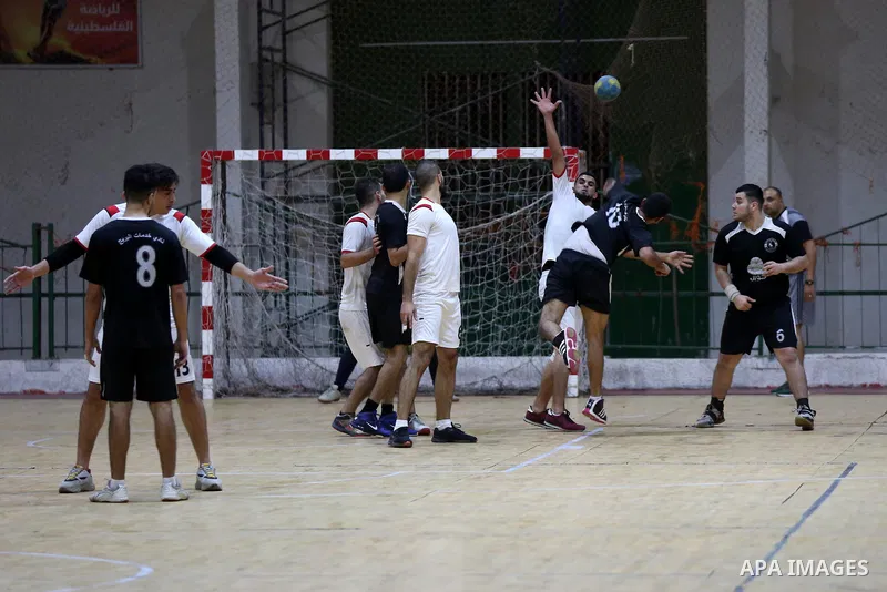 Palestinian handball players from the Etihad Deir Al-Balah (White) and khadamat Al-Bureij (Black) compete during the Cup Final in Saad Sayel gymnasium, in Gaza City on November 16, 2020. Photo by Ashraf Amra