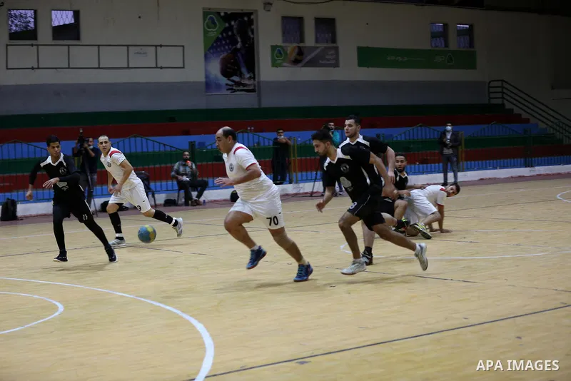 Palestinian handball players from the Etihad Deir Al-Balah (White) and khadamat Al-Bureij (Black) compete during the Cup Final in Saad Sayel gymnasium, in Gaza City on November 16, 2020. Photo by Ashraf Amra